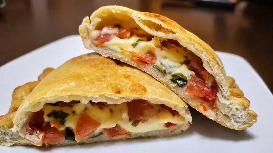 Empanada caprese de La Patrona cortada, con tomate, queso y albahaca
